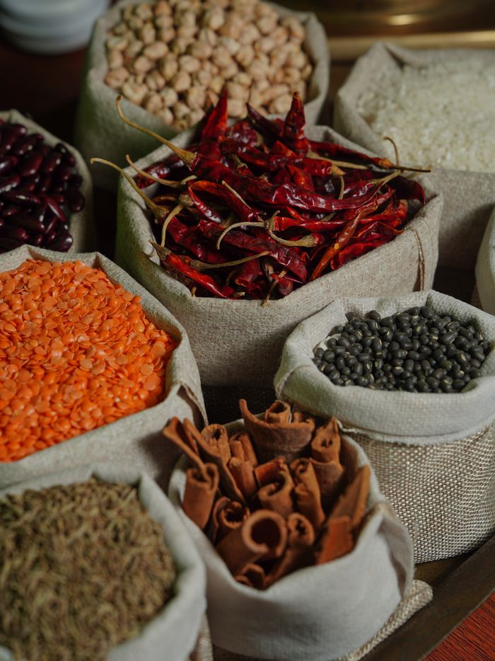 Assorted spices and grains in burlap bags, perfect for culinary exploration and food photography.